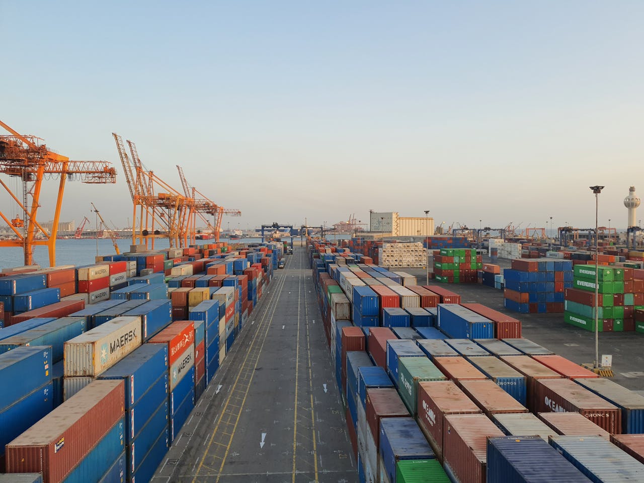 A bustling port scene with colorful cargo containers at sunrise. Ideal for logistics concepts.